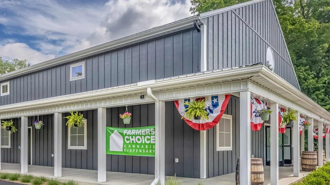 Farmers Choice dispensary building with patriotic bunting and green sign