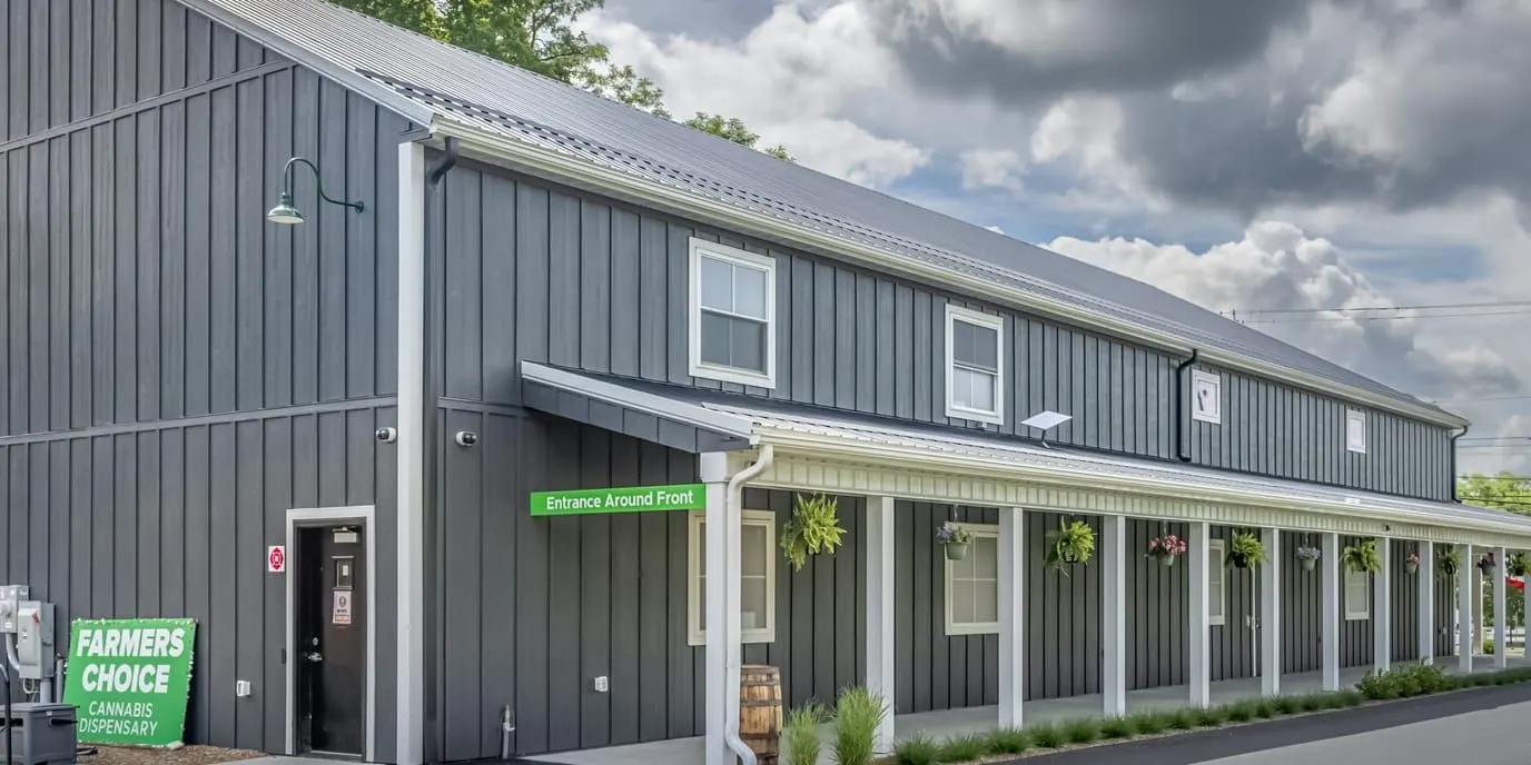 Side view of Farmers Choice dispensary building with green sign